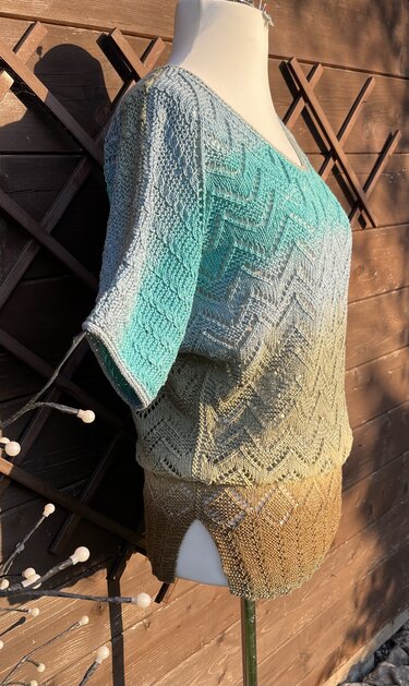 Mannequin trägt gestrickte Kurzarm-Tunika in Farbverlauf von Türkis zu Beige mit Zickzackmuster und V-Ausschnitt