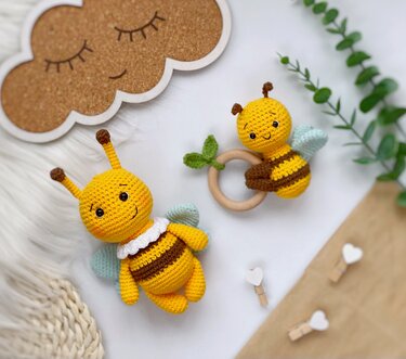 Zwei gehäkelte Bienen-Amigurumi, eines als Kuscheltier, eines am Holz-Greifring