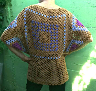 Person von hinten in gehäkeltem Boho-Oberteil mit großem quadratischem Granny-Muster