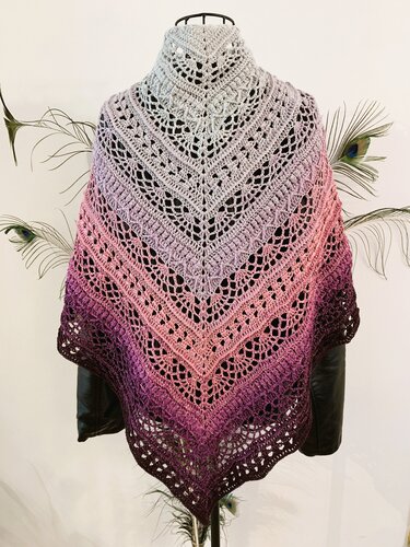 Triangular crochet lace shawl in pale gray, pink and deep purple ombre draped on a mannequin