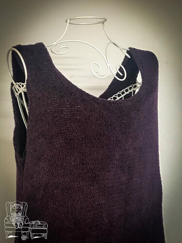 Dunkelviolettes Strickkleid mit leicht flauschiger Oberfläche auf einer weißen Schneiderpuppe