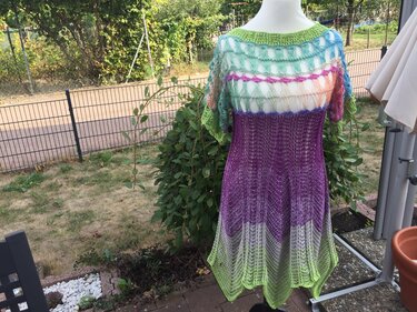 Gehäkeltes Damenkleid mit Netzoberteil und mehrfarbigem Farbverlauf (Grün–Lila) auf Schaufensterpuppe