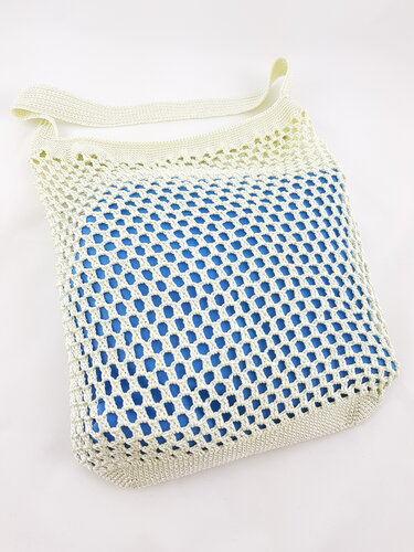 Hellbeige gehäkelte Netztasche mit blauem Innenfutter auf weißem Hintergrund