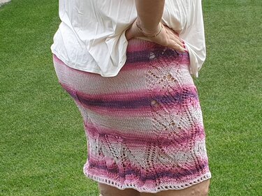 Seitenansicht eines kurzen gestrickten Rocks in Rosa und Lila mit Lochspitzenmuster