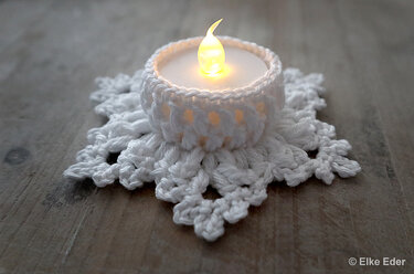 White crochet snowflake coaster with matching tealight cozy on wood