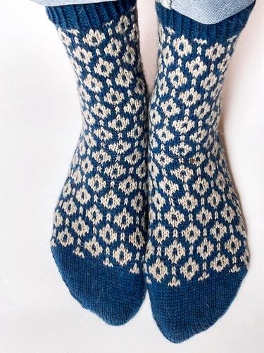 Nahaufnahme zweifarbiger gestrickter Socken mit Rautenmuster in Blau und Weiß