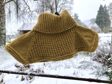Senfgelbes Kindercape gestrickt mit hohem Rollkragen und Rippenmuster