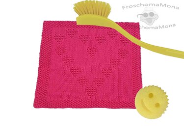 Rosa gestricktes Spültuch mit erhabenen Herzmotiven, gelbe Bürste und gelber Schwamm