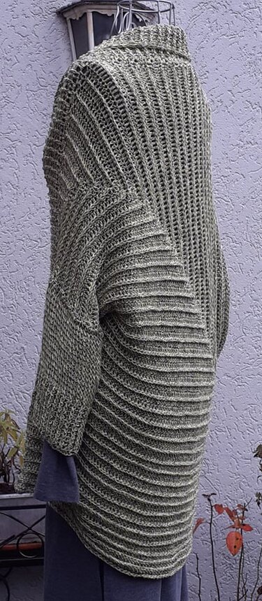 Rückenansicht eines olivgrünen, gehäkelten Oversize-Seelenwärmers auf einer Schaufensterpuppe