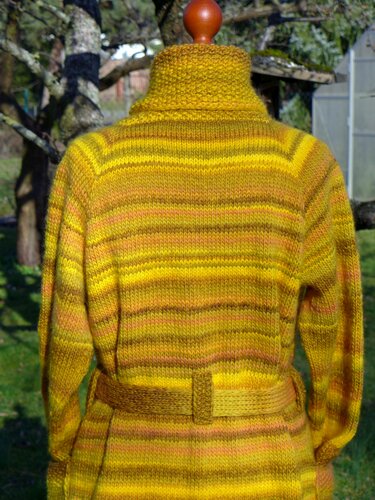 Rückansicht gestrickte Damenjacke in Gelb- und Brauntönen mit Streifen und Taillengürtel auf Puppe im Freien.
