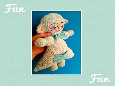 Detailansicht einer gehäkelten Amigurumi-Katze mit Fokus auf Maschen, gestickten Details und Tasche
