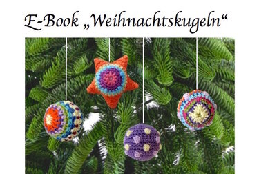 Vier gehäkelte Weihnachtskugeln und ein Stern in leuchtenden Farben hängen an einem grünen Weihnachtsbaum. Die Ornamente zeigen Muster wie Ringe, Punkte und bunte Streifen.