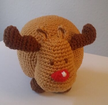 Gehäkeltes Amigurumi-Rentier mit braunem Körper, dunklen Geweihen und roter Nase