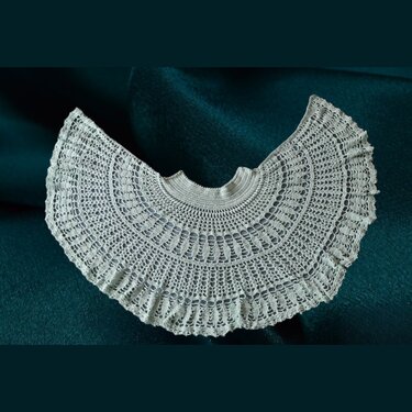 Halbrundes gehäkeltes Spitzentuch in hellem Cremeweiß auf dunklem Hintergrund