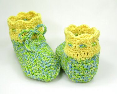 Paar gehäkelter Schuhe in Gelb, Grün und Blau mit gewelltem Rand und Schnürung
