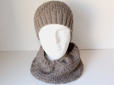 Beigefarbene Strickmütze und Loop-Schal auf Mannequin