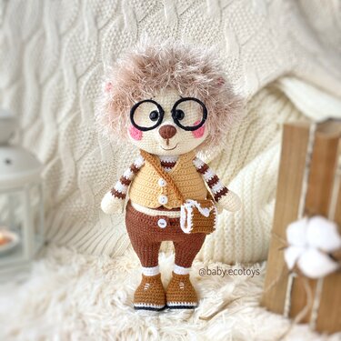 Gehäkeltes Igel-Amigurumi mit flauschigem Kopf, runder Brille und Umhängetasche