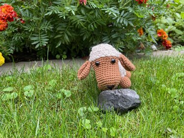gehäkeltes Amigurumi-Schaf braun-weiß im Gras