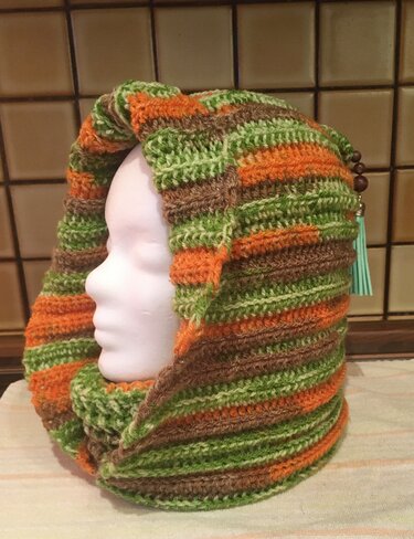 Gehäkelter Kapuzenloop in Grün, Orange und Braun mit Perlen-Quaste