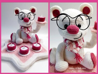 Weißer gehäkelter Amigurumi-Bär mit rosa Details, Schal, Drahtbrille und vier kleinen gehäkelten Kerzen auf sternförmigem Teppich