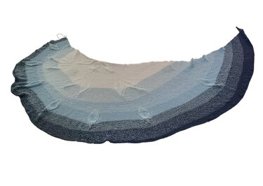 Halbrundes gestricktes Tuch mit blauem Farbverlauf und eingestrickten Blattmotiven.