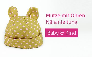 Babymütze mit Öhrchen aus senffarbenem Stoff mit rosa Herzen und Umschlagbund