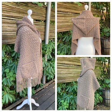 Beiger gehäkelter Scoodie mit Kapuze, aufgesetzter Tasche und Fransen an einer Schaufensterpuppe vor grünem Hintergrund