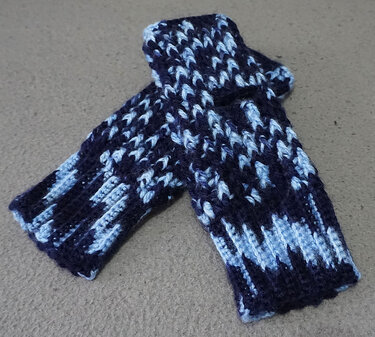 Zwei gehäkelte fingerlose Handschuhe in dunkelblau und hellblau mit geripptem Bündchen