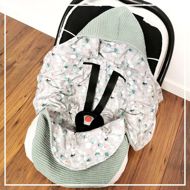 Babyschalen-Einlage in Mint mit Waffelkapuze, gemustertem Innenfutter und sichtbarem Gurtschloss