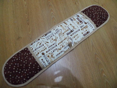 Langer Topflappen in Braun und Beige mit Kaffee-Schrift und Kaffeebohnenmuster, mittige Schlaufe