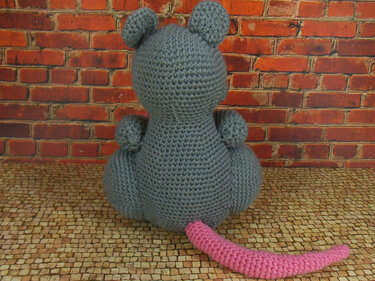 Gehäkelte graue Amigurumi‑Maus Rückansicht mit rosa Schwanz