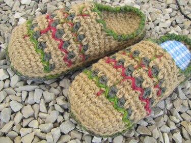 Gehäkelte beige Hausschuhe mit grünen, roten und grauen Zierstichen und blau-kariertem Innenfutter