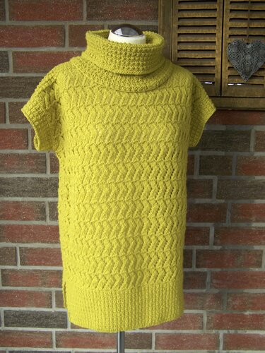 Gestrickter Damenpullover in Gelbgrün mit Rollkragen und kurzen Ärmeln auf einer Schaufensterpuppe.