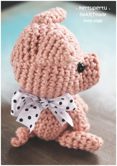 Gehäkeltes rosa Amigurumi‑Schwein mit gepunkteter Schleife, seitliche Nahansicht