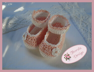 Gehäkelte rosa-weiße Baby-Ballerinas mit Riemchen und Blütenapplikation