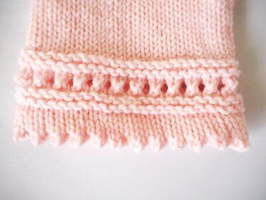 Hellrosa gestricktes Armstulpen-Bündchen mit Lochreihe und gezacktem Rand