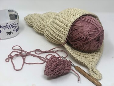 Nahaufnahme gehäkeltes Utensilo aus dickem Garn mit Häkelnadel