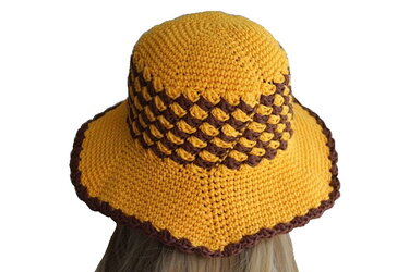 Gehäkelter Damenhut gelb-braun mit Bobbelmuster am Hutband, Rückansicht auf blondem Haar.