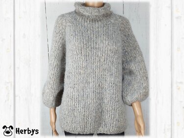 Hellgrauer Damen-Strickpullover mit hohem Kragen und weiten Ärmeln auf Mannequin