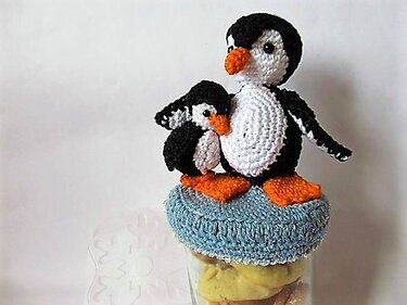 Gehäkelte Pinguin-Applikationen als Deckelüberzug auf einem Glas