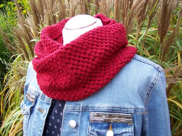 Weinroter Loopschal locker um den Hals einer Schaufensterpuppe mit Jeansjacke drapiert, Gartenhintergrund