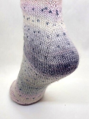 Detailansicht der Ferse einer pastellfarbenen, glatt rechts gestrickten Socke
