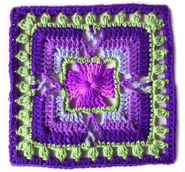 Gehäkeltes Quadrat mit zentralem Blütenstich, abgestuften violetten Runden und grüner Blattborte