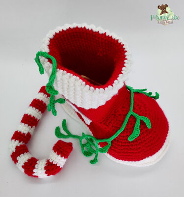 Gehäkelter roter und weißer Weihnachtsstiefel mit grünen Ranken und gestreiftem Griff