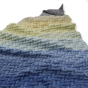 Gestricktes Dreieckstuch mit Korbmuster/Flechtstruktur und Farbverlauf von Blau über Gelb zu Grau, Nahaufnahme