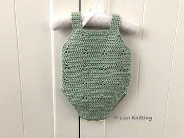 Light green crocheted baby romper on padded baby hanger.
