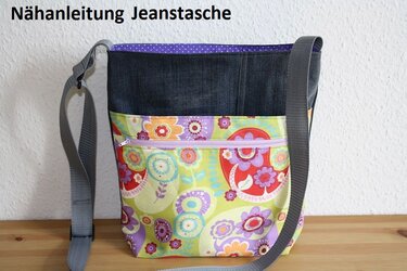Selbstgenähte Umhängetasche aus Jeansstoff und buntem Blumenstoff mit lila Reißverschluss und grauem Schultergurt