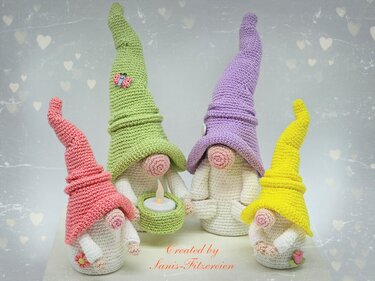 Vier zarte Pastell-Wichtel aus Häkelgarn mit langen Mützen und verschiedenen dekorativen Details