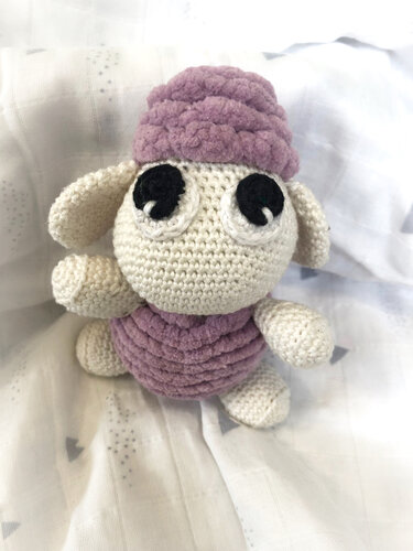 Gehäkeltes Amigurumi-Schaf mit cremefarbenem Kopf und fliederfarbenem, geripptem Körper
