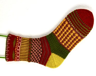 Bunte gestrickte Socke mit Streifen-, Karo- und Reliefmustern auf weißem Hintergrund